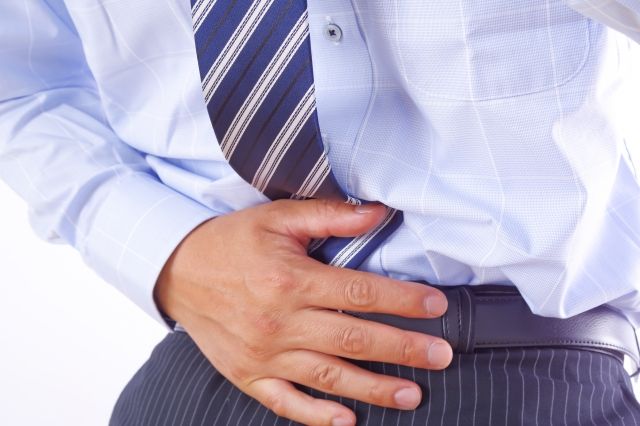 下腹部を押さえる男性